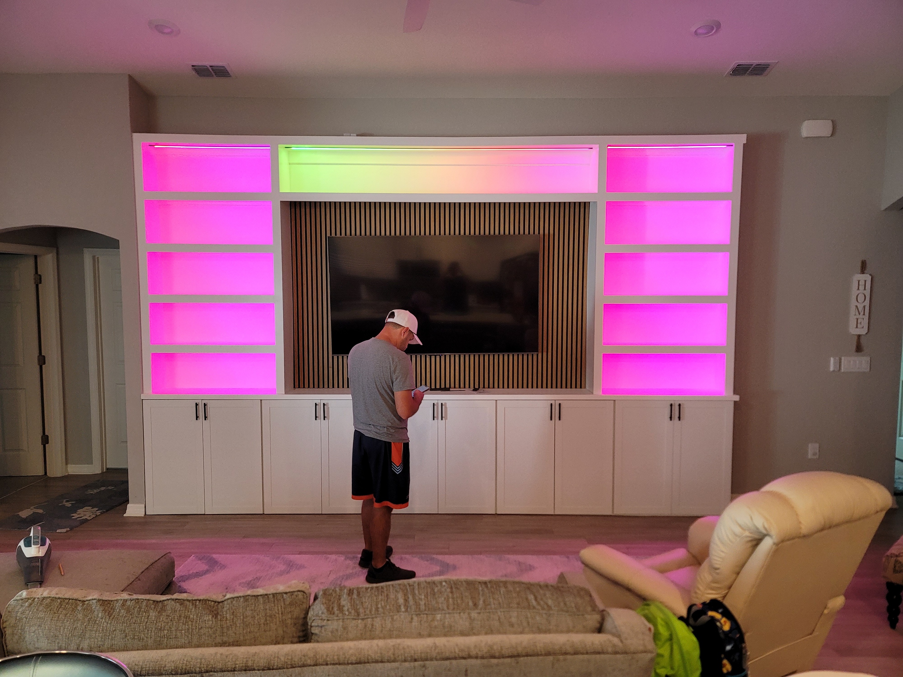 Custom built-in with White shaker cabinets and acoustic panel accents in the center also including smart LED lighting.